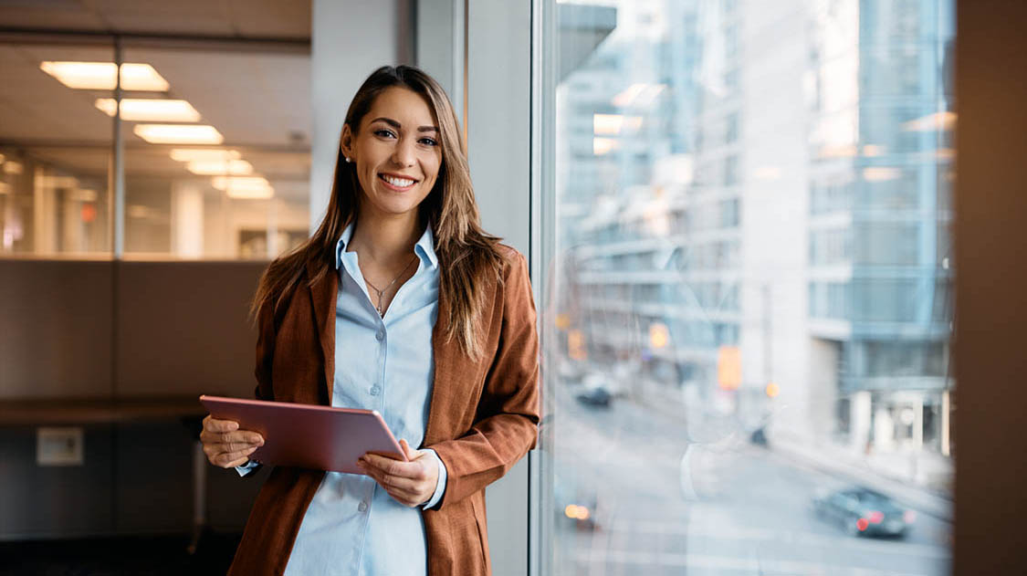 Portrait of happy businesswoman with touchpad in office looking at camera. Portrait of happy businesswoman with touchpad in office looking at camera.